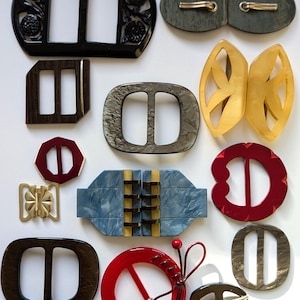 Viele alte farbige Gürtelschnallen aus verschiedenen Materialien und in vielen Formen.