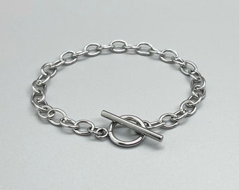 May include: A silver chain bracelet with a toggle clasp.