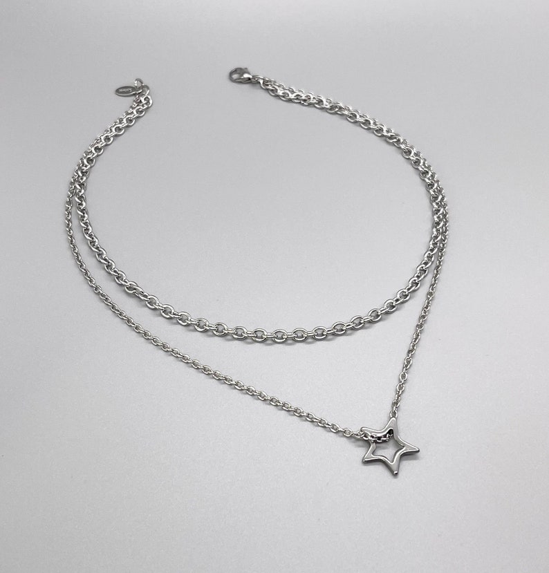 May include: A silver layered chain necklace with a star pendant.