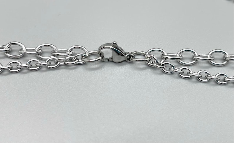 May include: A silver chain necklace with a lobster clasp closure.