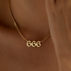 May include: A gold chain necklace with a pendant featuring the number 666 in a gothic font.