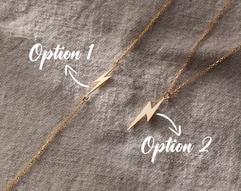 May include: Two gold necklaces with lightning bolt pendants. The necklace on the left has the pendant in the middle of the chain, while the necklace on the right has the pendant at the end of the chain. The text "Option 1" and "Option 2" are written on the image.
