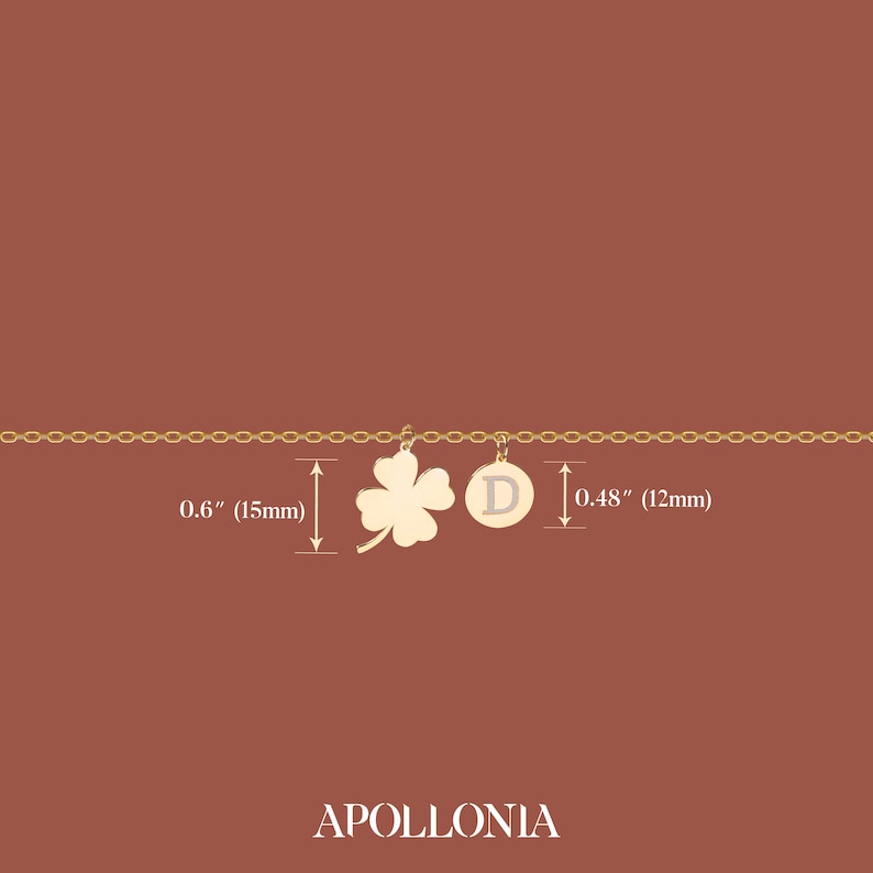 May include: Gold chain necklace with a four-leaf clover charm and a round charm with the letter "D" on it. The clover charm is 0.6 inches (15 mm) wide and the round charm is 0.48 inches (12 mm) wide.