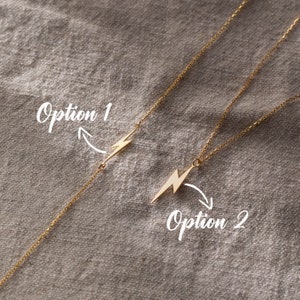 May include: Two gold necklaces with a lightning bolt pendant. The first necklace has the pendant in the center of the chain. The second necklace has the pendant hanging from the end of the chain. The text "Option 1" and "Option 2" are written on the image.