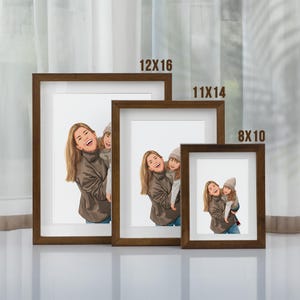 May include: Three brown picture frames with white mats and different sizes. The frames are arranged from largest to smallest. The largest frame is 12x16 inches, the middle frame is 11x14 inches, and the smallest frame is 8x10 inches.