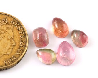 May include: Five pink, green, and orange gemstone cabochons in various shapes, including teardrop and oval, next to an Australian coin for size comparison.
