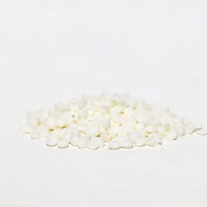 May include: A pile of small, white, round sugar crystals.