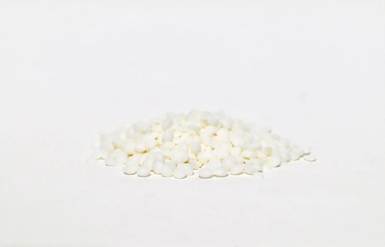 May include: A pile of small, white, round sugar crystals.