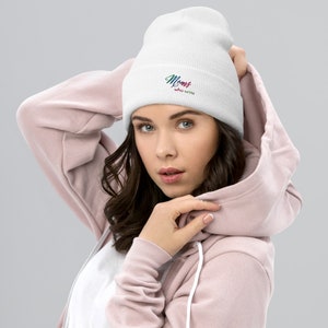 May include: White beanie with the text "Moms who write" in rainbow colours.