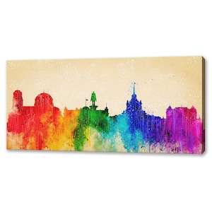 May include: A colorful cityscape silhouette with a rainbow watercolor effect. The skyline is painted in shades of red, orange, yellow, green, blue, indigo, and violet.
