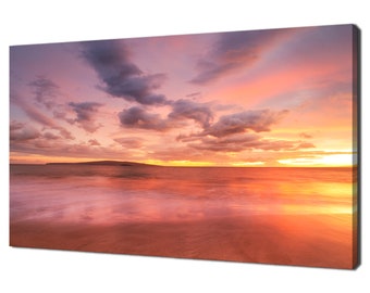May include: A vibrant sunset over a calm ocean with a small island in the distance. The sky is a mix of pink, orange, and purple, with fluffy clouds. The water is a deep blue, reflecting the colors of the sky.