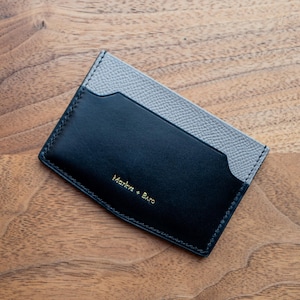 Das Kartenportemonnaie petite V-ausgeschnitten. Schmales und kompaktes 3 cc Kartenportemonnaie aus salzgrauem Epsom und schwarzem Boxkalbsleder. Luxus minimalistisches EDC.