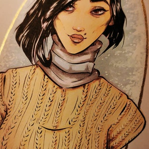 May include: A hand-drawn illustration of a woman with dark hair wearing a brown knitted sweater and a white turtleneck. The illustration is set against a light blue background with gold accents.