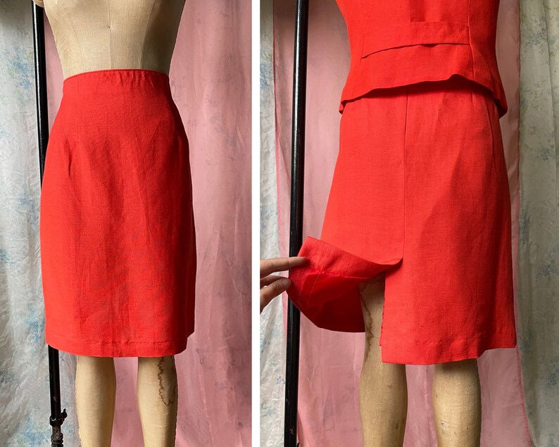 May include: A bright red skirt suit with a straight skirt and a fitted jacket. The skirt has a centre back seam and the jacket has a single button closure.