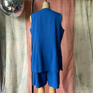 Op de afbeelding: Een blauwe, mouwloze jurk met een bijpassend short. De jurk heeft een V-hals en een simpel ontwerp.