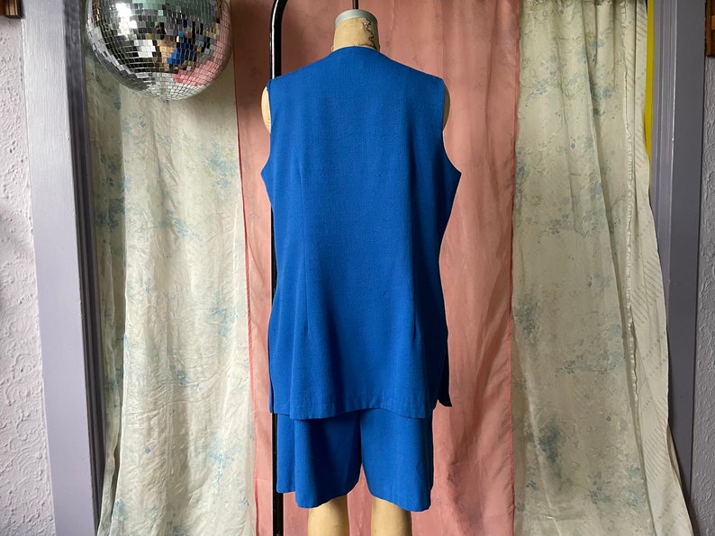Op de afbeelding: Een blauwe, mouwloze jurk met een bijpassend short. De jurk heeft een V-hals en een simpel ontwerp.