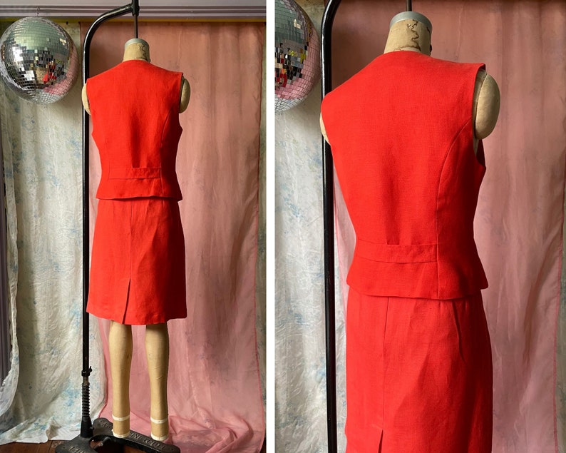 May include: A sleeveless red dress with a matching waistcoat. The dress has a fitted bodice and a skirt that falls to the knee. The waistcoat has a pointed collar and a button closure.