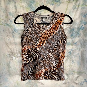 May include: A sleeveless top with a brown, black, and white animal print. The print features a leopard, zebra, and cheetah pattern.