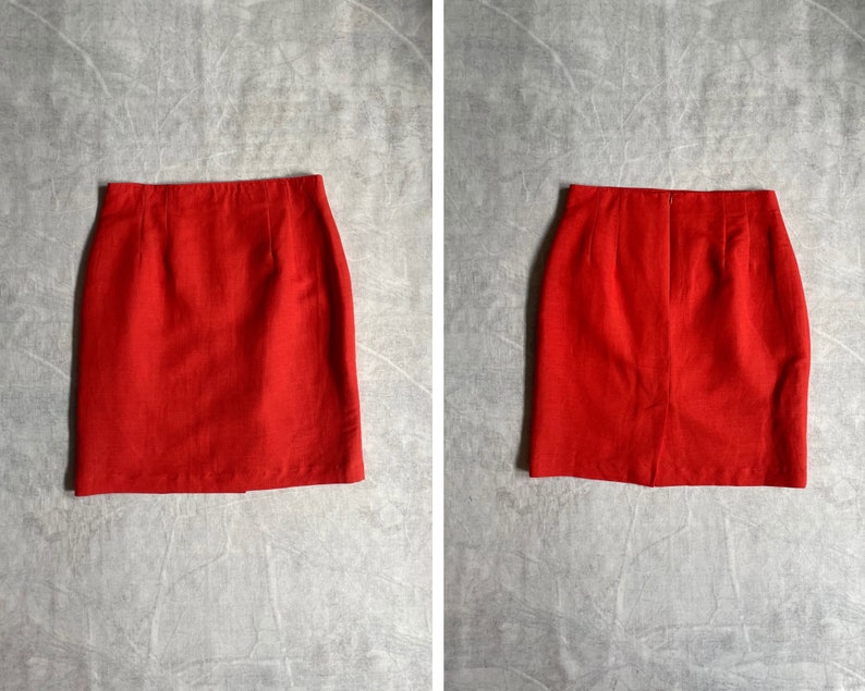 May include: A red mini skirt with a straight cut and a zip at the back.