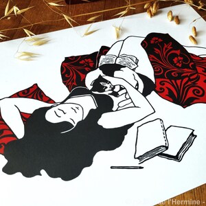 May include: Black and white illustration of a person reclining with a cat, reading a book. The person is wearing a black top and is resting on a red pillow with a black floral design. Two books and a pencil are also visible.