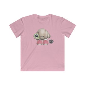 May include: A pink t-shirt with a cartoon image of a hermit crab wearing pink shoes and holding a small bucket of sand.