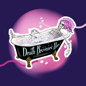 Könnte beinhalten: Ein schwarz-weißes Skelett in einem rosa Bademantel entspannt sich in einer schwarzen Badewanne voller Blasen. Die Badewanne hat goldene Füße und der Text "Death Becomes Her" steht an der Seite.