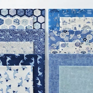 May include: A collection of blue and white patterned fabric squares. The fabrics feature geometric designs, floral patterns, and koi fish.
