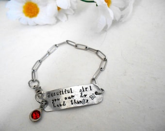 May include: Silver chain bracelet with a charm that reads "Beautiful girl you can do hard things" with a small red gemstone charm.
