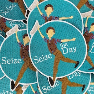Könnte beinhalten: Eine Sammlung runder, türkisblauer gestickter Patches mit weißen Nähten. Jeder Patch zeigt eine Comicfigur in brauner Kleidung, die ein weißes Objekt hält, mit dem Text "Seize the Day" in weißen Buchstaben.