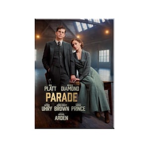 May include: A movie poster for the film "Parade" starring Ben Platt and Micaela Diamond. The poster features a black and white image of the two actors in formal attire, standing in a dimly lit room. The title of the film is written in large, gold letters.
