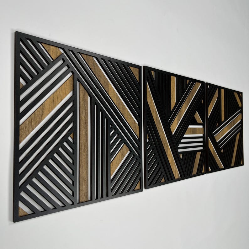 May include: Three black and brown geometric wall panels with a modern design. The panels are made of wood and have a layered effect.