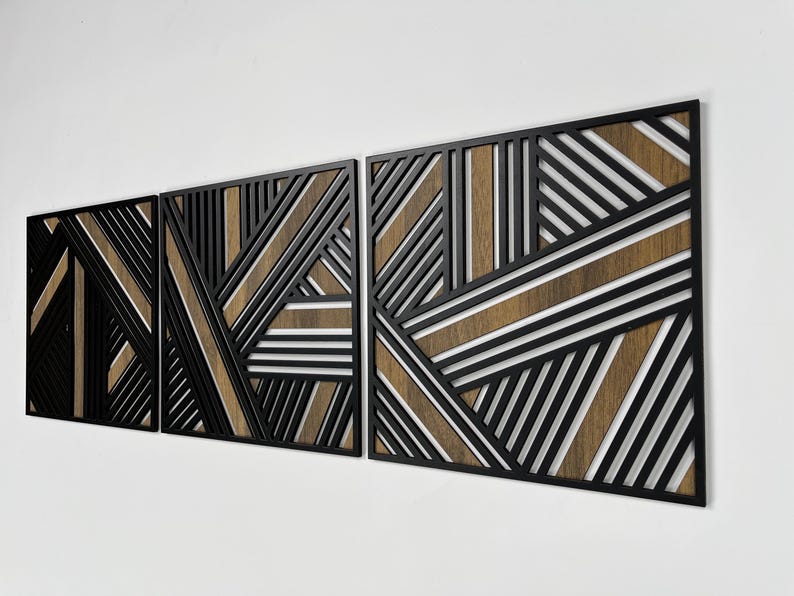 May include: Three black metal wall panels with a geometric pattern of intersecting lines. The panels are layered to create a three-dimensional effect. The background of the panels is a light brown wood.