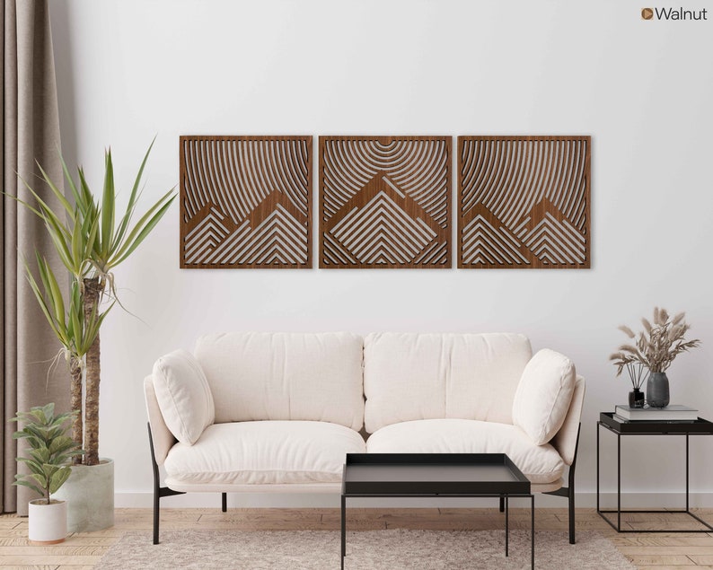 May include: Three wooden wall panels with a geometric mountain design. The panels are in a walnut finish and are arranged in a row on a white wall.