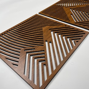 May include: Two brown wooden wall panels with a geometric pattern of lines and curves.