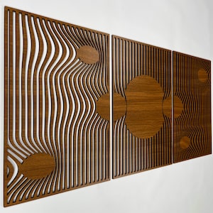 May include: Three wooden wall panels with a mid-century modern design. The panels are made of dark brown wood and feature vertical lines and circular cutouts. The design creates a sense of depth and movement, suitable for a living room.