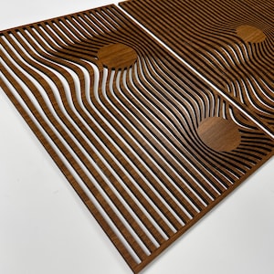 May include: Wooden wall art panels with a unique design. The panels are made of brown wood and feature a series of curved, parallel lines. The design includes circular accents, creating a modern, abstract aesthetic. The panels are displayed against a white background.