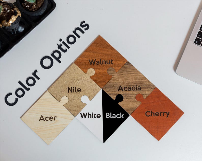 May include: A collection of wooden puzzle pieces in various colors, including walnut, acacia, cherry, and black. The text "Color Options" is displayed in black, along with the names of each color on the puzzle pieces.