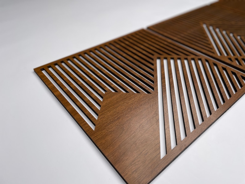 May include: Two brown wooden wall panels with a geometric pattern of diagonal lines cut out. The panels are made of wood with a dark brown stain.