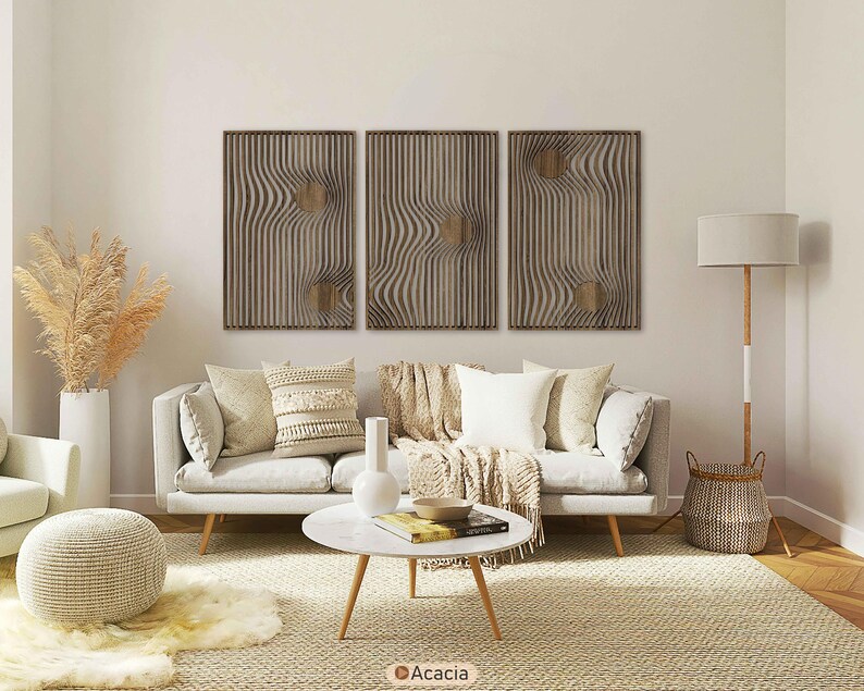 May include: Three wooden wall art panels with a wavy, textured design and a circular accent. The panels are displayed above a light-colored sofa with decorative pillows and a throw blanket. The room has a neutral color palette.