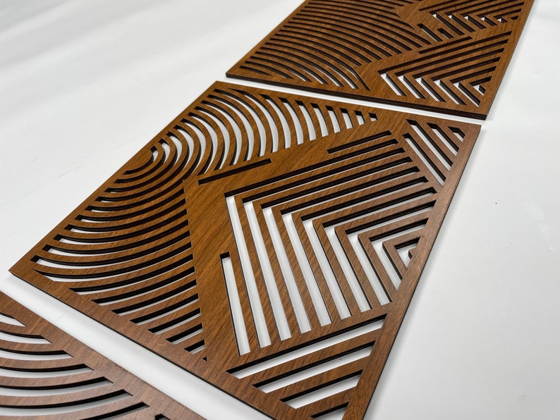 May include: Three wooden wall decor panels with a geometric pattern of lines and curves. The panels are made of a dark brown wood and have a natural wood grain finish.