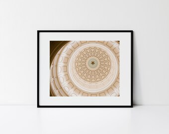 May include: A close-up view of the interior of a domed building, showing a circular pattern of white and gold trim with a single gold star in the center.