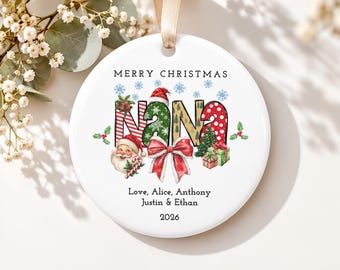 May include: A round white ceramic ornament featuring the word NANA in colorful holiday patterns. The design includes a Santa Claus face, a large red bow, a Christmas tree, and gifts. Text reads MERRY CHRISTMAS, Love, Alice, Anthony, Justin & Ethan, 2026.