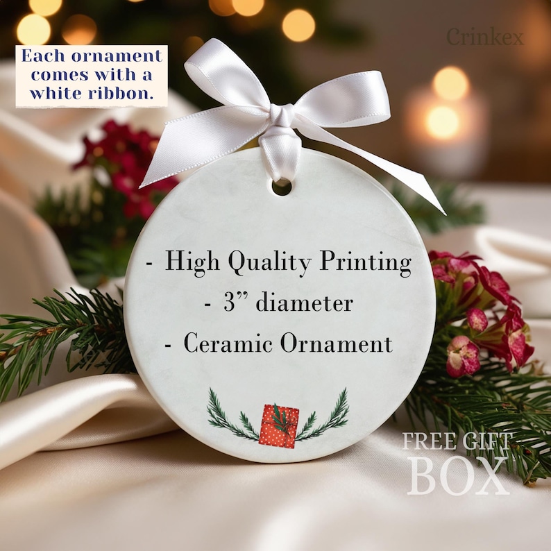 Puede incluir: Un adorno redondo de cer&aacute;mica blanca con una cinta blanca. El texto dice: Each ornament comes with a white ribbon, High Quality Printing, 3 inch diameter, Ceramic Ornament. En la parte inferior hay un peque&ntilde;o gr&aacute;fico de regalo rojo.