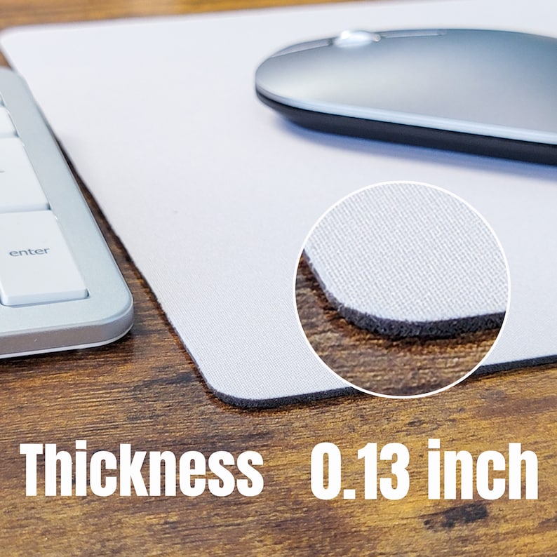 May include: White mouse mat with a black stitched edge. The mouse mat is 0.13 inches thick and has a textured surface.