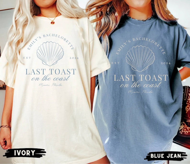 K&ouml;nnte beinhalten: Zwei &uuml;bergro&szlig;e T-Shirts mit einem Muschel-Motiv und dem Text "Emily's Bachelorette Est 2024 Last Toast on the Coast Miami Florida". Das Shirt links ist elfenbeinfarben und das Shirt rechts ist jeansblau.
