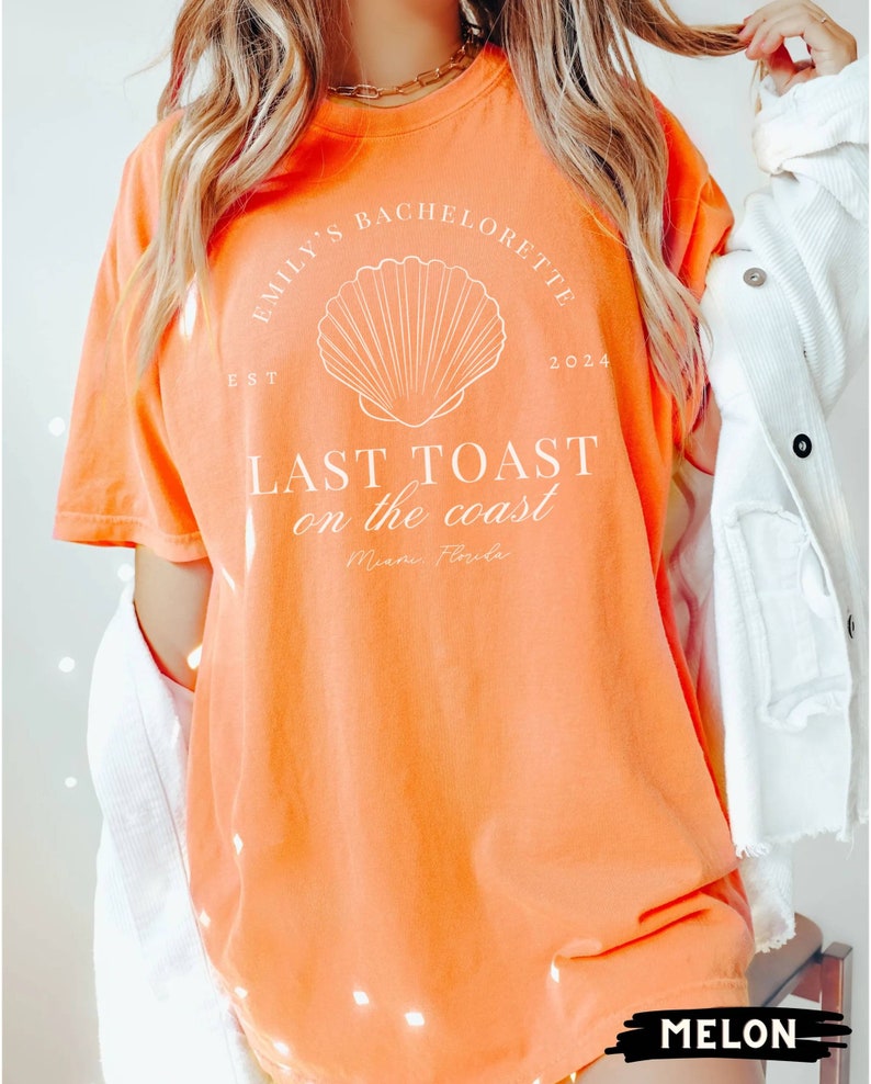 K&ouml;nnte beinhalten: Orangefarbenes T-Shirt mit wei&szlig;em Text, der "Emily's Bachelorette 2024 EST LAST TOAST on the coast Miami Florida" lautet, und einer wei&szlig;en Muschelgrafik.
