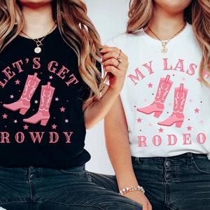 Puede incluir: Dos camisetas, una negra y otra blanca, con un dise&ntilde;o de botas de vaquero rosas. La camiseta negra dice "LET'S GET ROWDY", la blanca "MY LAST RODEO". Ambas con estrellas rosas, ideal para un evento.