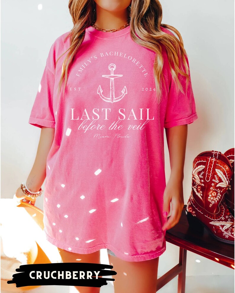 May include: Pink oversized t-shirt with white text that reads "Emily's Bachelorette Est. 2024 Last Sail Before the Veil Miami, Florida". The shirt features a white anchor graphic.