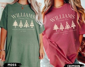 Könnte beinhalten: Zwei Damen-T-Shirts mit einem Weihnachtsbaum-Design und dem Text "Williams Christmas Crew Making Memories Together est. 2021". Das Shirt links ist moosgrün und das Shirt rechts ist rot.