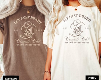 Puede incluir: Dos camisetas beige con temática de vaquera. La camiseta de la izquierda dice "Let's Get Rowdy" con un dibujo de un sombrero de vaquero y botas. La camiseta de la derecha dice "My Last Rodeo" con un dibujo de un sombrero de vaquero y botas. Ambas camisetas dicen "Cowgirls Club" y "Jenna's Bachelorette".